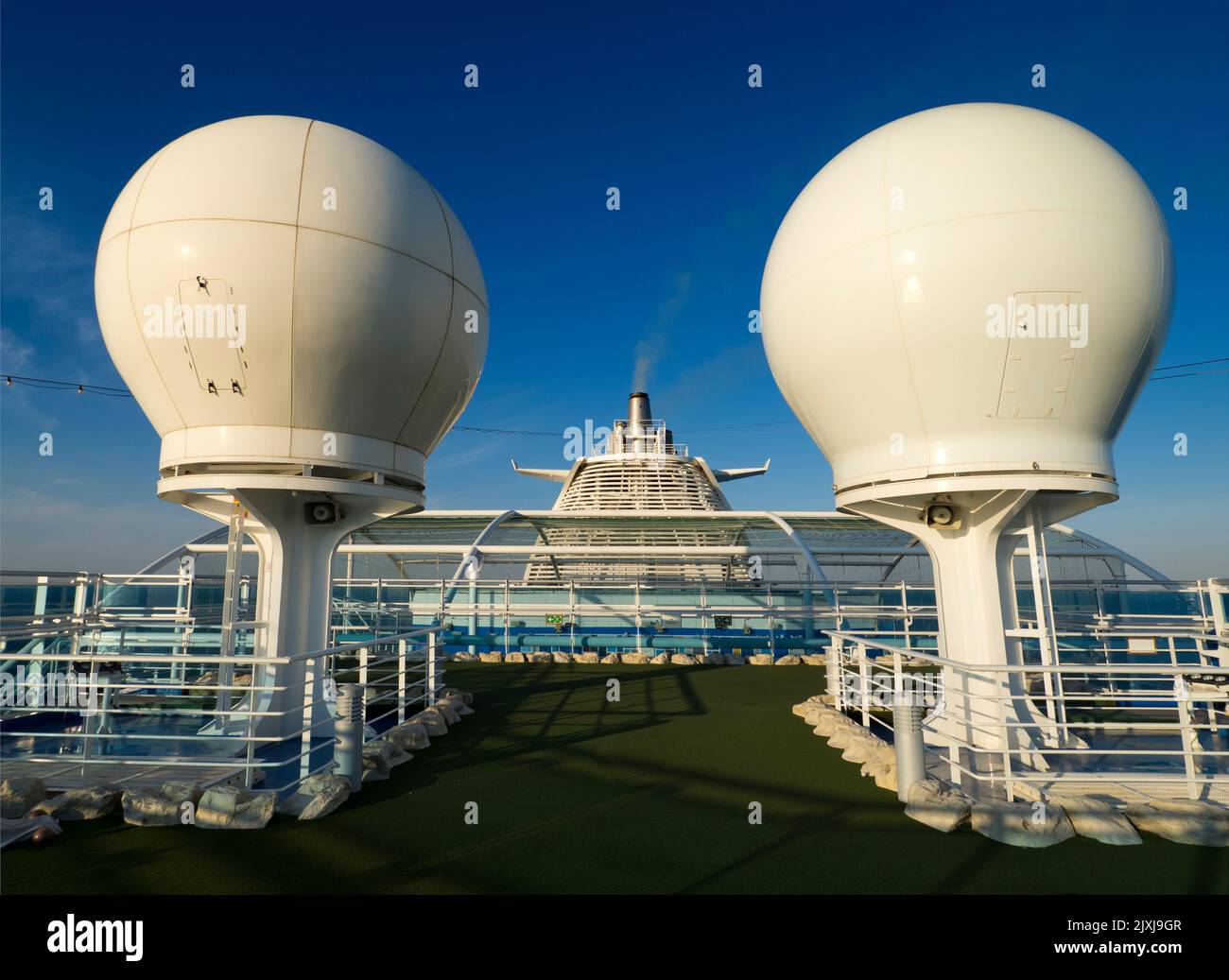 Think of the most surreal spot for a putting course. How about the top deck of a cruise liner? Well, this is the view from on, dominated by the ship's Stock Photo
