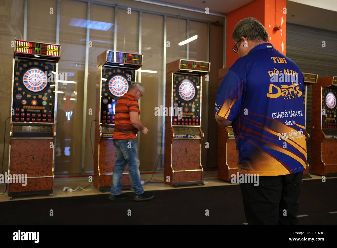 Two senior darts player taking turns one getting ready to play Stock