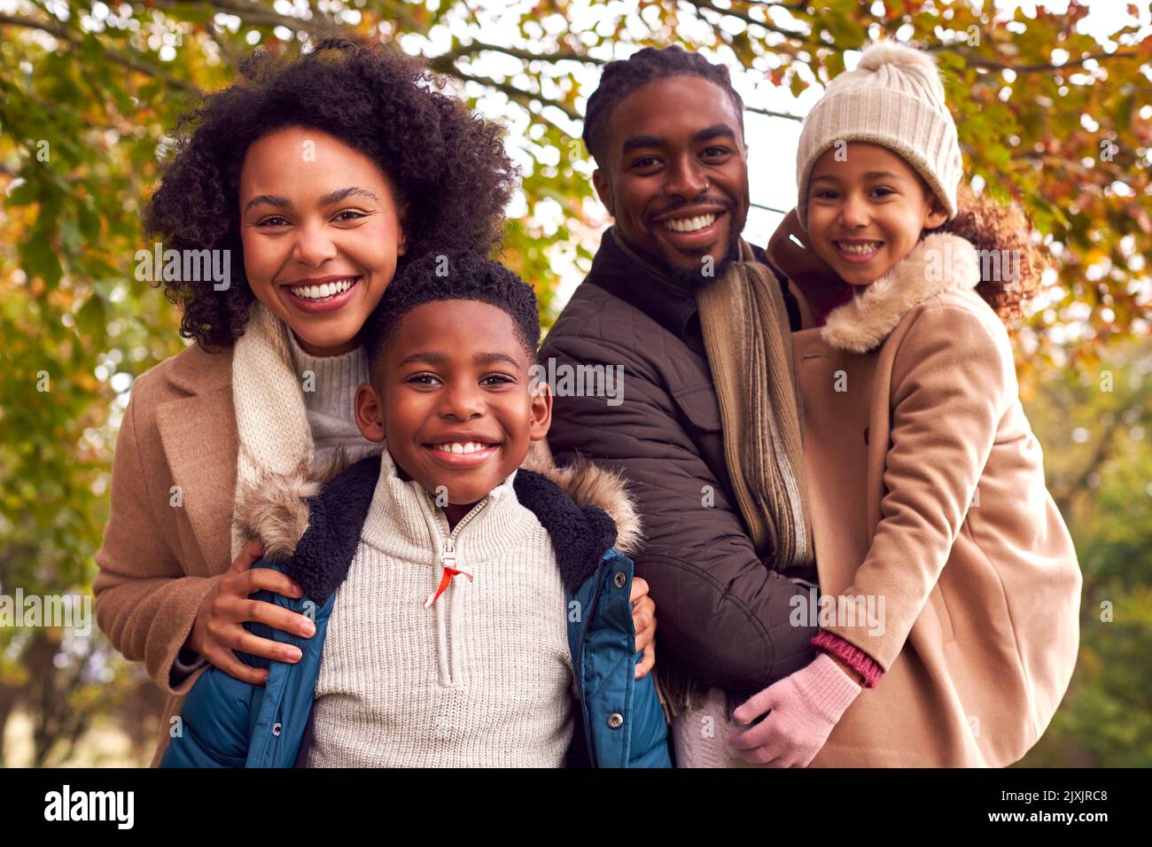 Portrait Of Smiling Family On Walk Through Countryside Against Autumn Trees Stock Photo