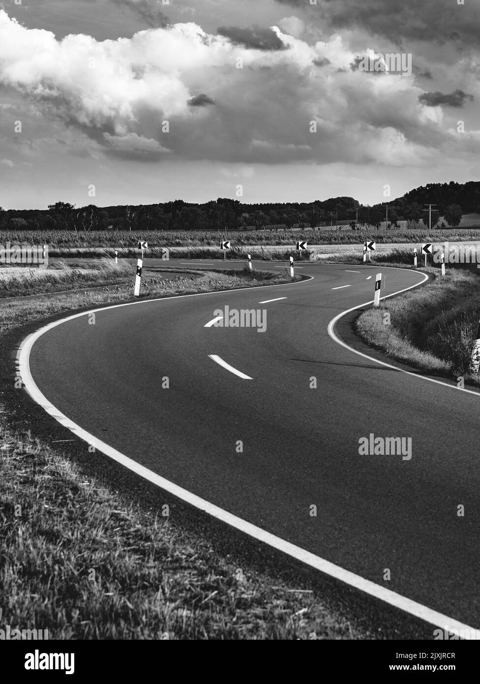 Artistic black and white photo of a empty winding road in Germany among ...