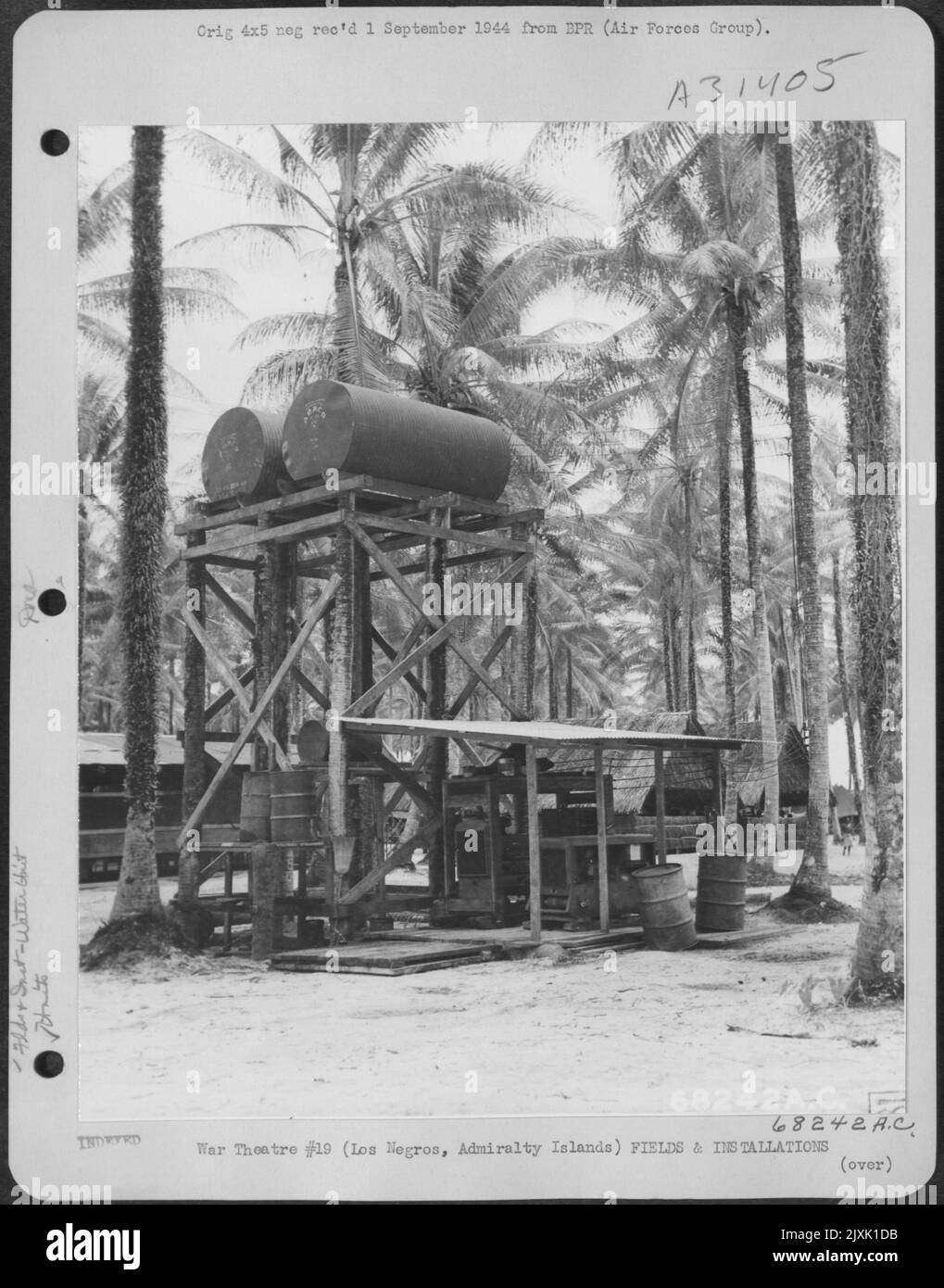 This is a view of the water supply tower in the 58th Evacuation Hospital area on Los Negros, Admiralty Islands. The water is pumped from a well into a purification unit and thence to tanks shown in this photo. The tanks hold 2400 gallons of water Stock Photo