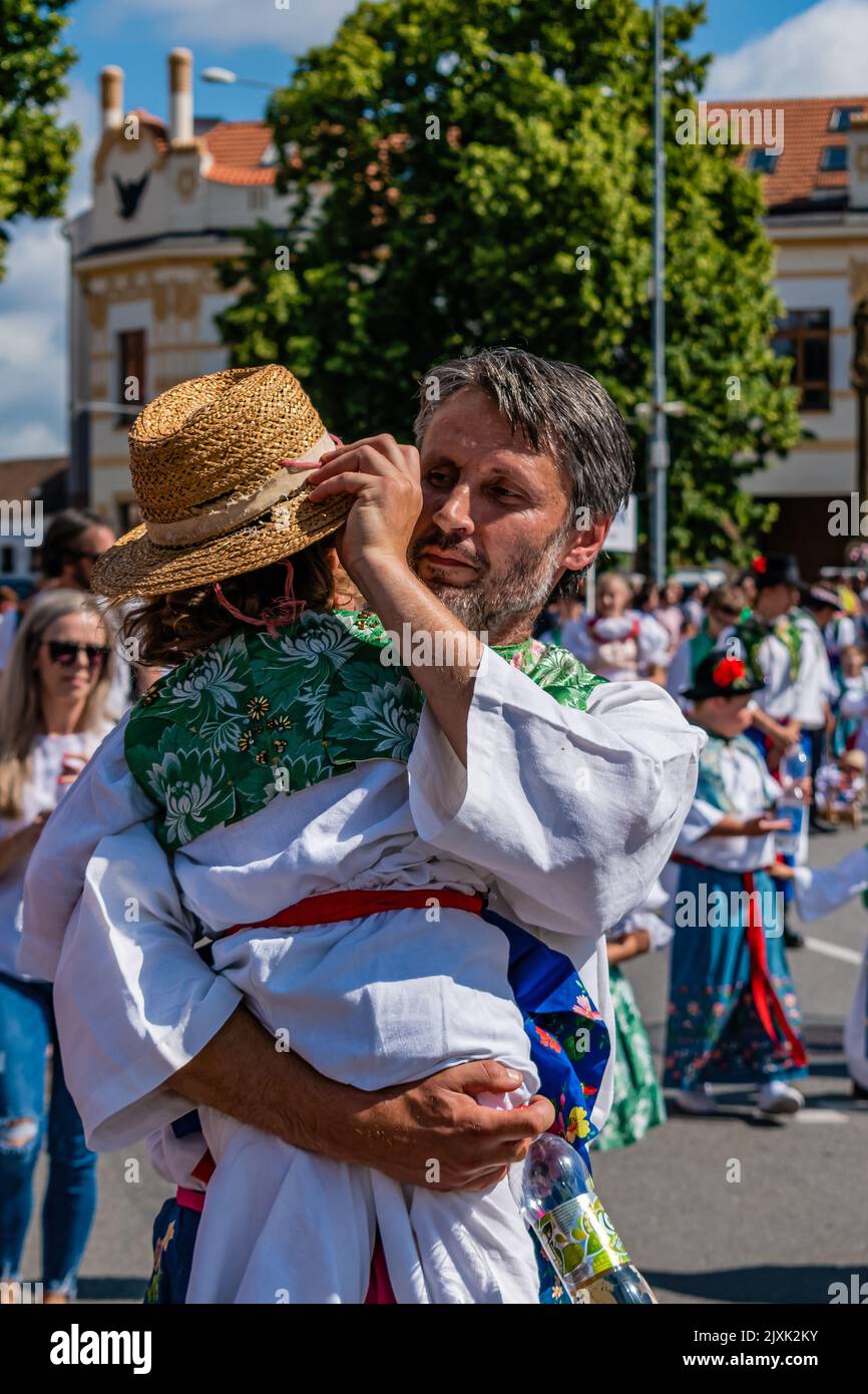 A man with a child in his arms at the international Folklore Festival, vertical shot Stock Photo