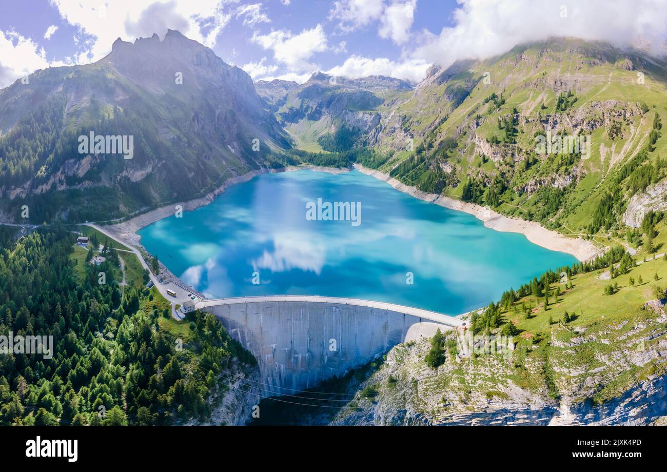 Water dam and reservoir lake in Swiss Alps mountains producing sustainable hydropower, hydroelectricity generation, renewable energy to limit global w Stock Photo