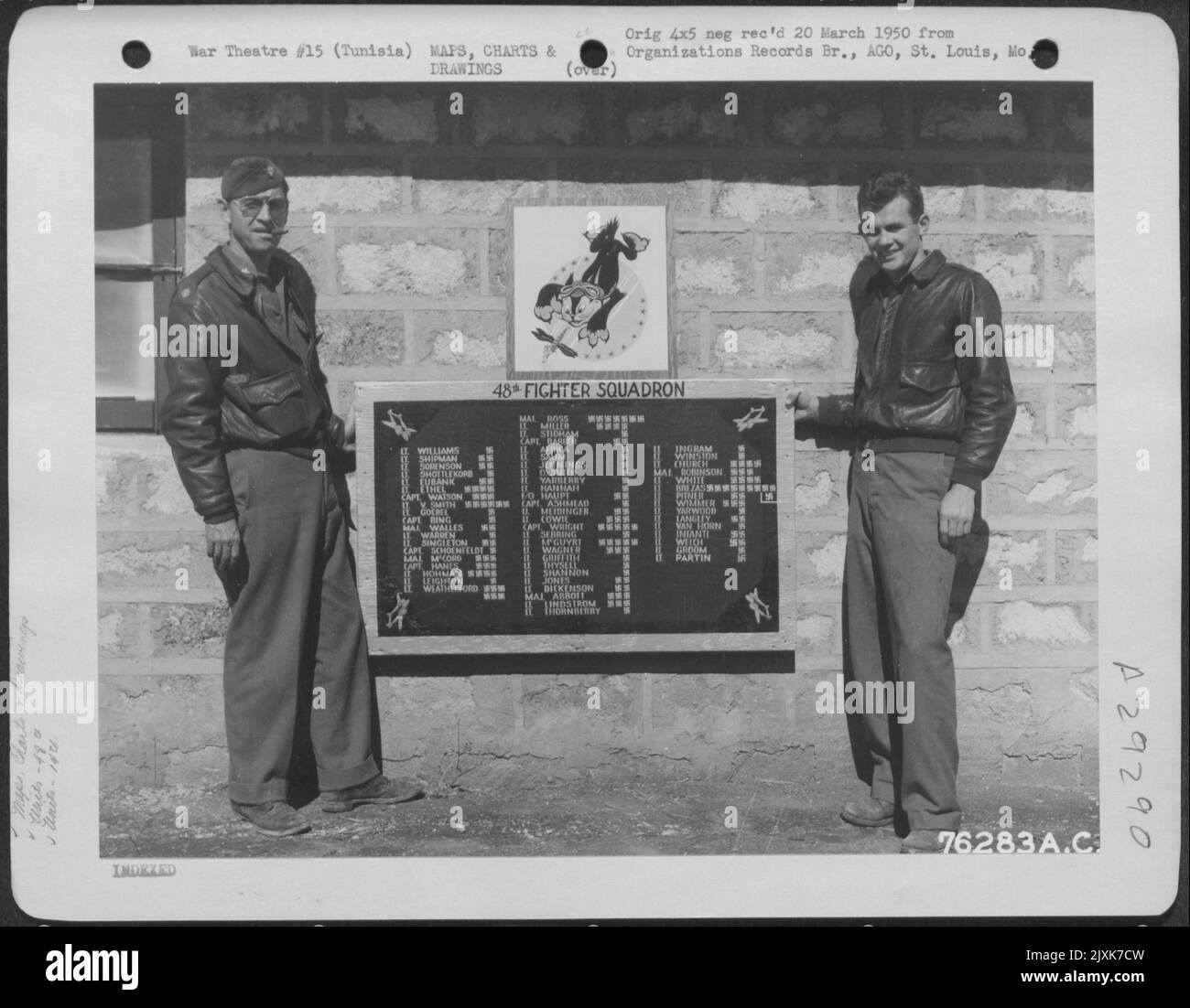 Two Members Of The 48Th Fighter Squadron, 14Th Fighter Group, Stationed At An Air Base Somewhere In Tunisia, Proudly Display A Poster Which Proclaims The Score Of The Units Fighter Pilots. 1943. Stock Photo