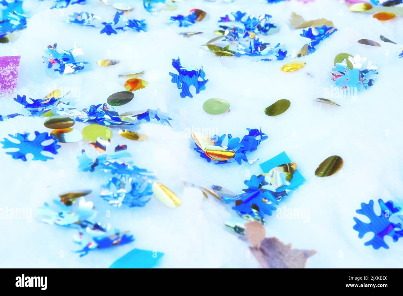 Decorative and festive Christmas confetti on the fresh white snow. Abstract holidays backgrounds Stock Photo