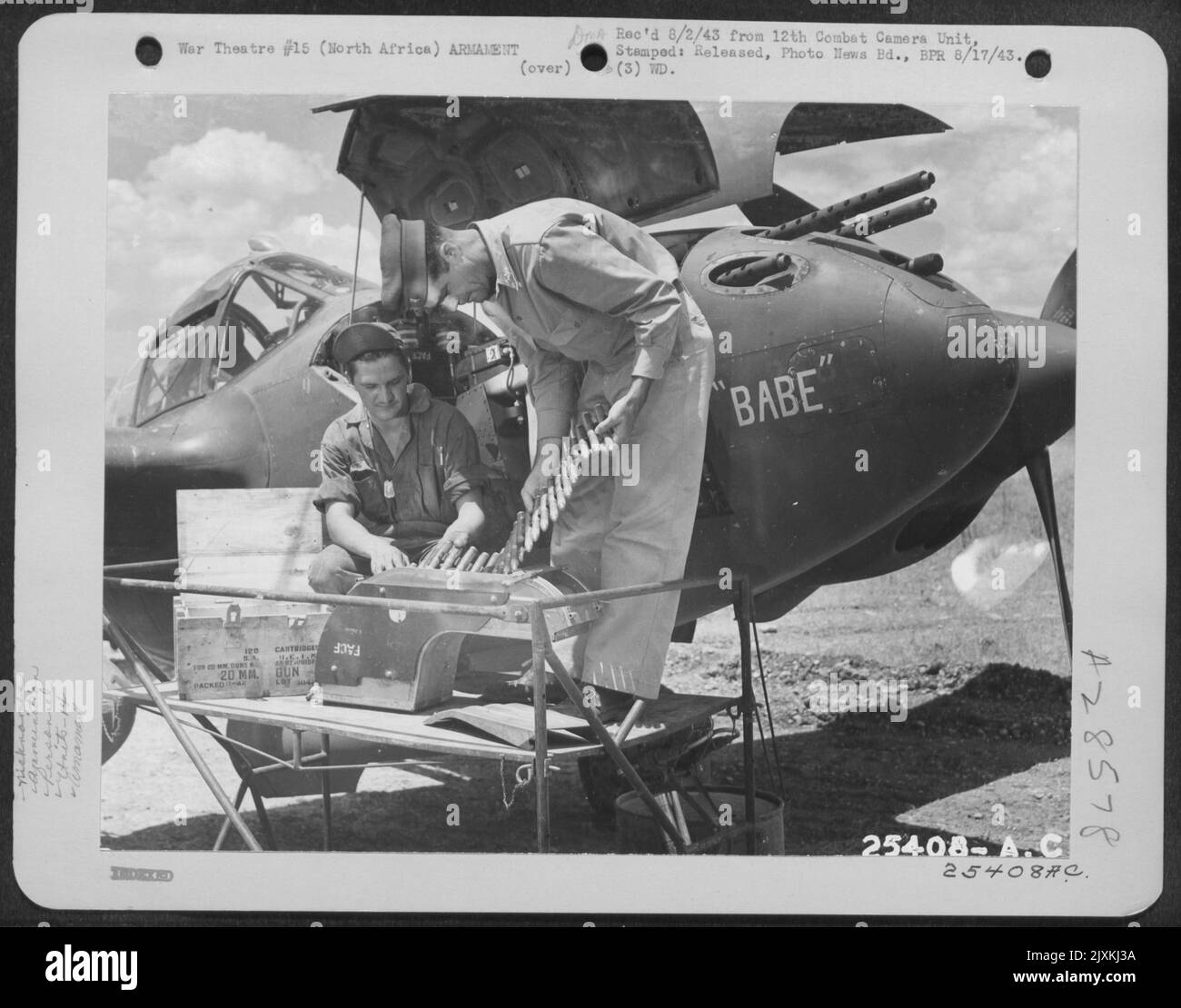 1st Lt. H.A. Blood examining ammunition being loaded into the Lockheed ...