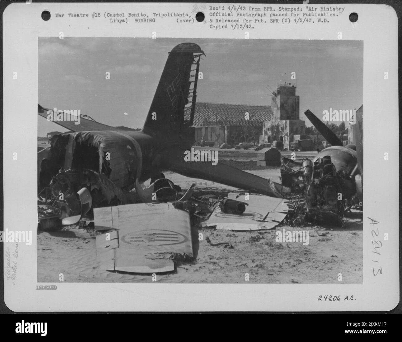 Smashed Nazi aircraft at the edge of the landing ground at Castel Benito, Tripolitania, Libya. Behind is the watch tower and the roofless hangars which were targets for Allied bombers. Stock Photo