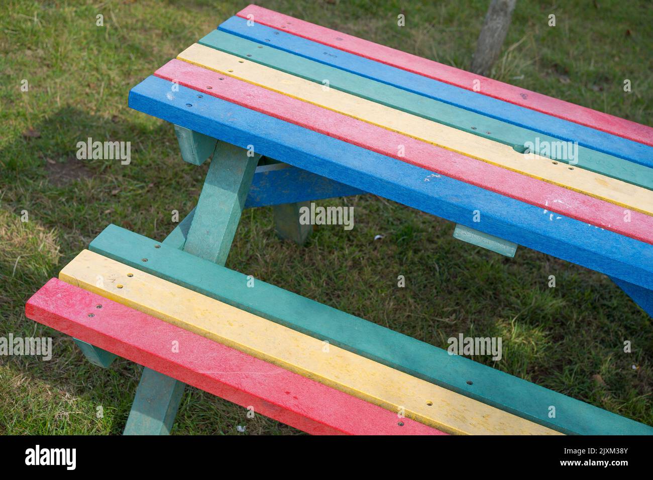 Rainbow coloured park bench Stock Photo
