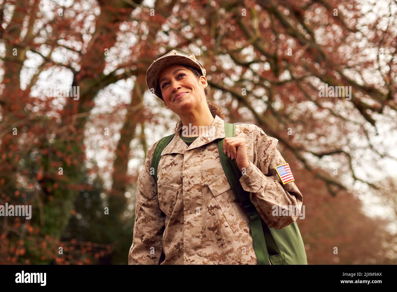 American Female Soldier In Uniform Carrying Kitbag Returning Home On Leave Stock Photo