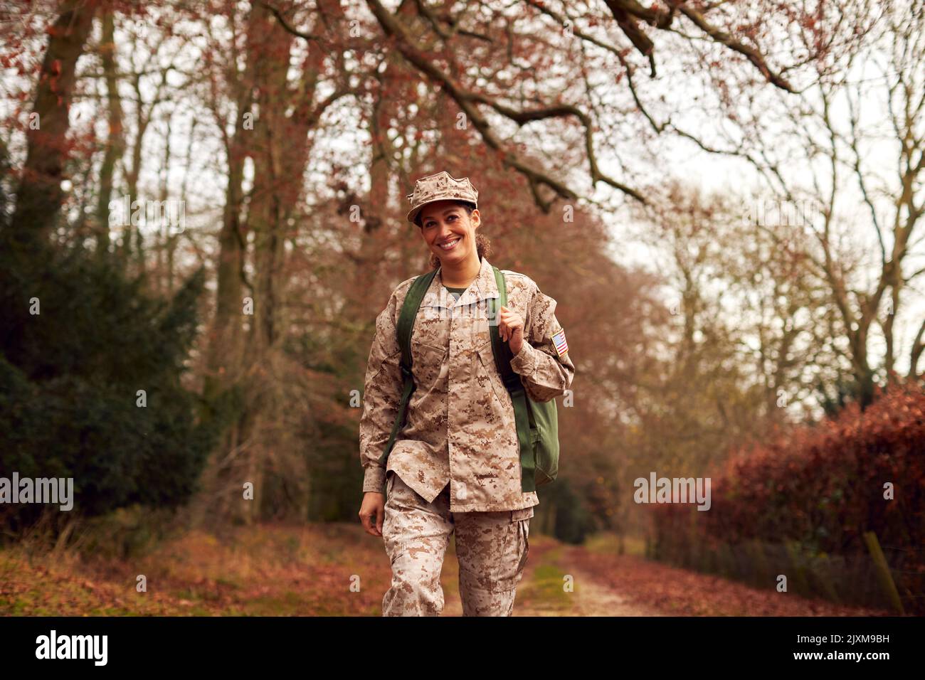 American Female Soldier In Uniform Carrying Kitbag Returning Home On Leave Stock Photo