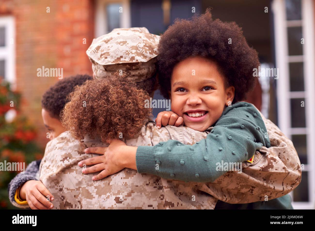 American Female Soldier In Uniform Returning Home To Family On Hugging