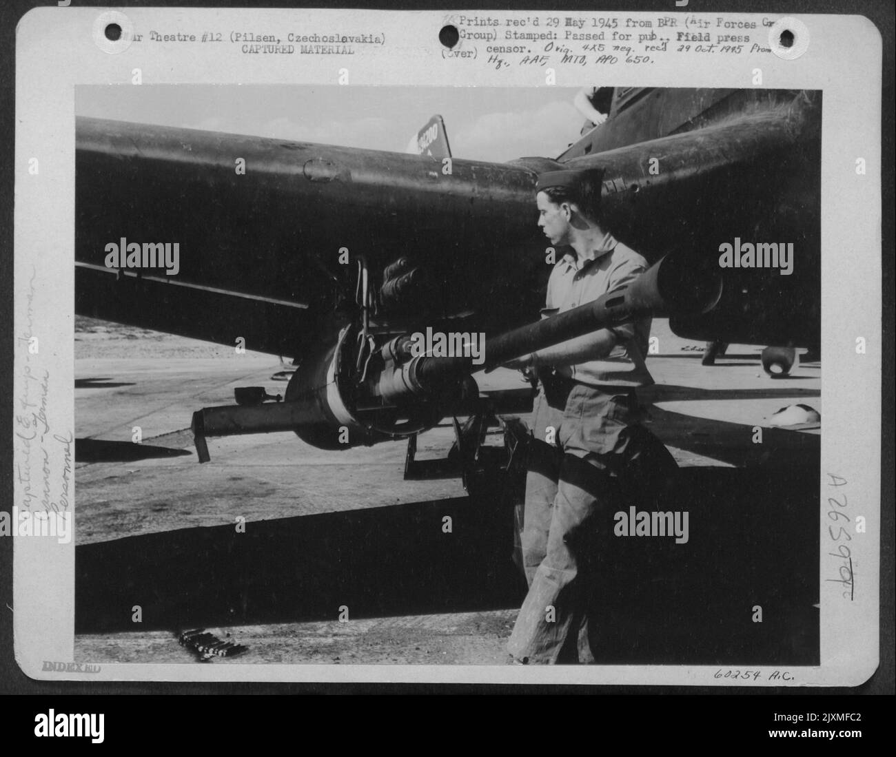 S/Sgt. Charles N. Culver, P.O. Box 283, Rosser, Texas, examines a 40 MM Cannon attached to the wing of a German JU-87 Stuka, used as an Anti-tank gun, at an airfield in Pilsen, CZECHOSLOVAKIA. Stock Photo