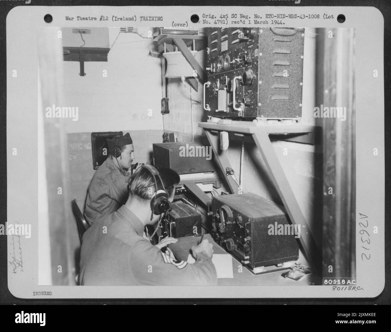 A Grope Cubical for training aerial navigators and radio operators as a team, at U.S. Army Air Force Station #236, in Northern Ireland. Operating the equipment are, left to right: 1st Lt. Edmund Johnson and T/Sgt. Michael Kruge, radio operators. Stock Photo