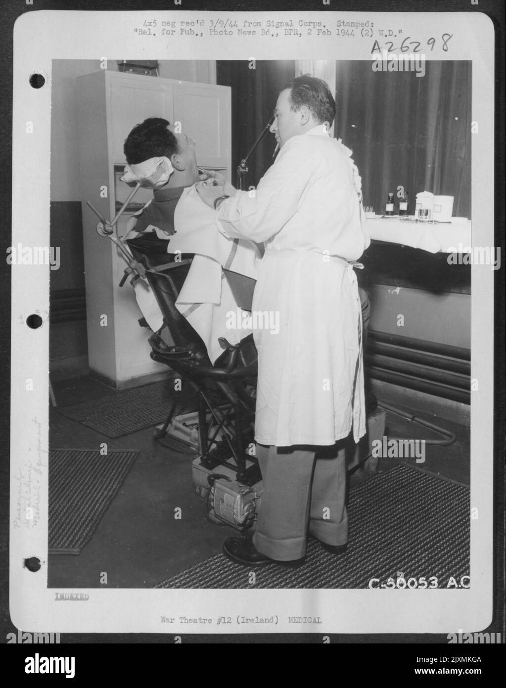 1st Lt. Herman Ivanhoe, Brooklyn, N.Y., dental surgeon, dental surgeon, with the aid of Pvt. Anthony Perri, New Haven, Conn., dental technician, shows the maneuverability of dental chair made from a pilot's seat by Lt. Ivanhoe. Stock Photo