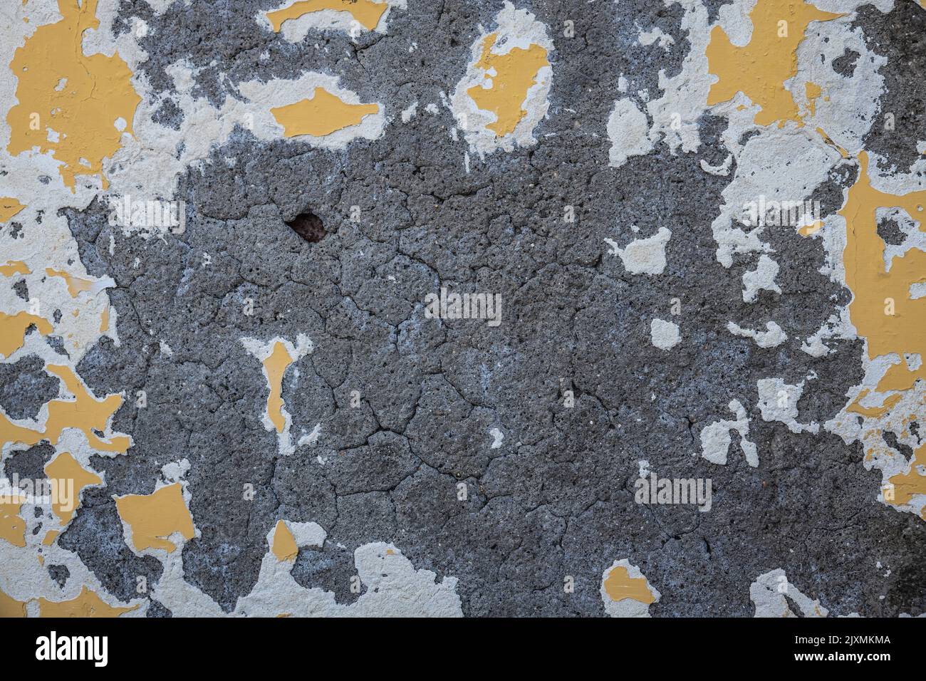 Abstract concrete and paint background with the yellow paint flacking ...