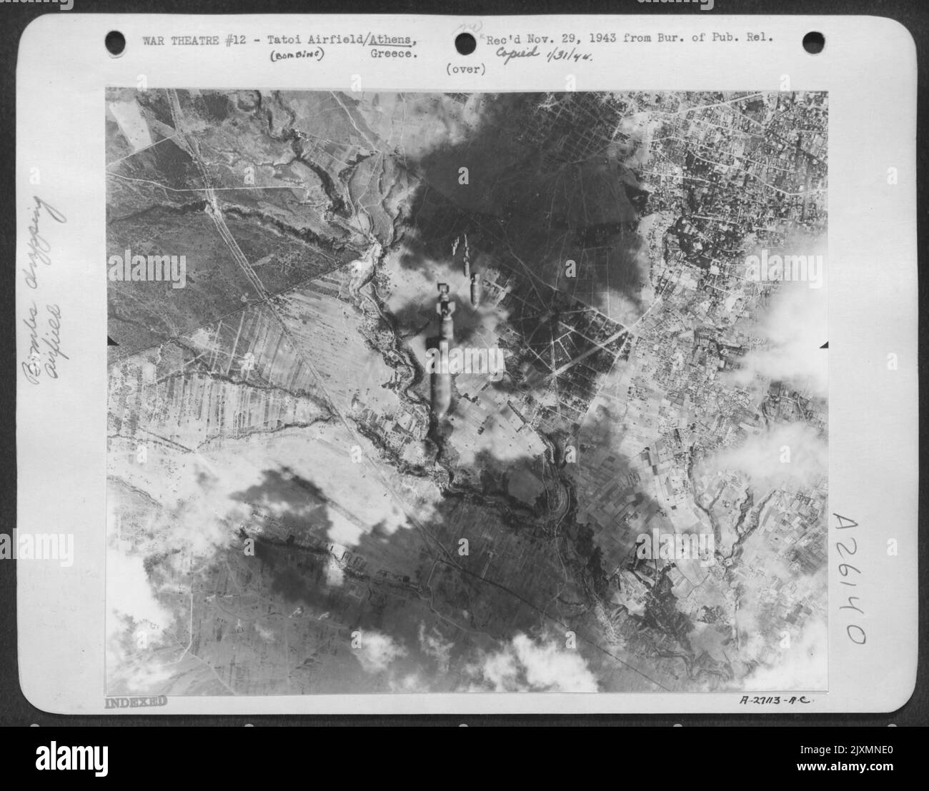 Bombs from a Flying Fortress of the Northwest African Air Forces fall on the Tatoi airfield