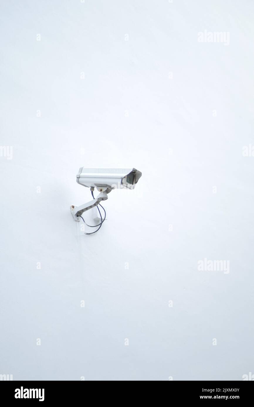 CCTV security camera operating on a white wall with copy space  Stock Photo