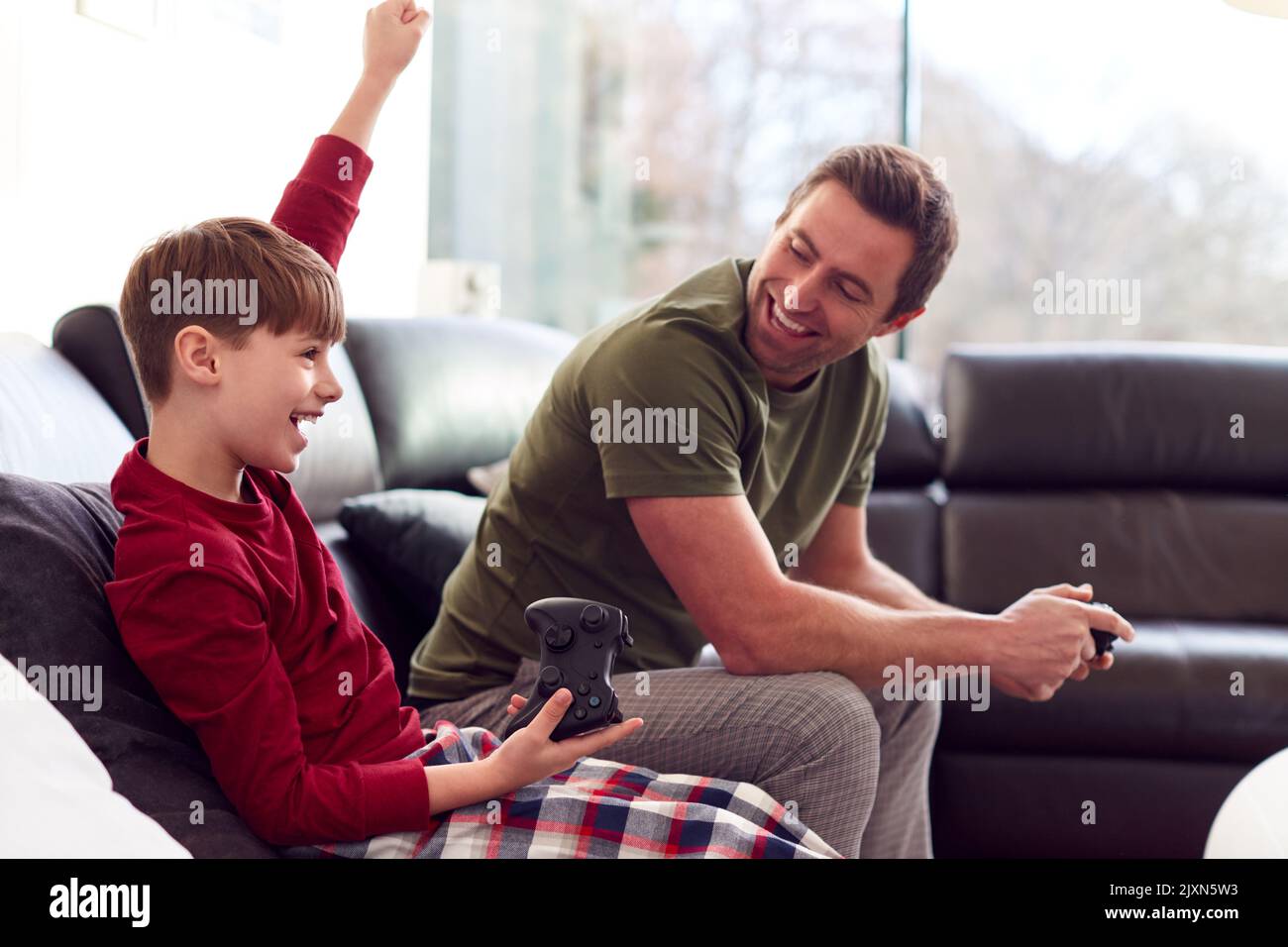 Boy In Pyjamas Wearing Virtual Reality Headset Playing Computer Game At Home Stock Photo