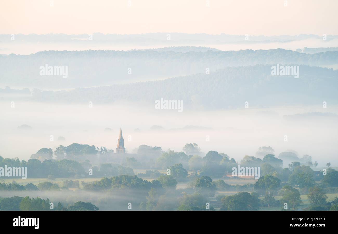 St Barnabas Church in Weeton is prominent in the Lower Wharfe Valley above Arthington Pastures on a hazy summer morning. Stock Photo