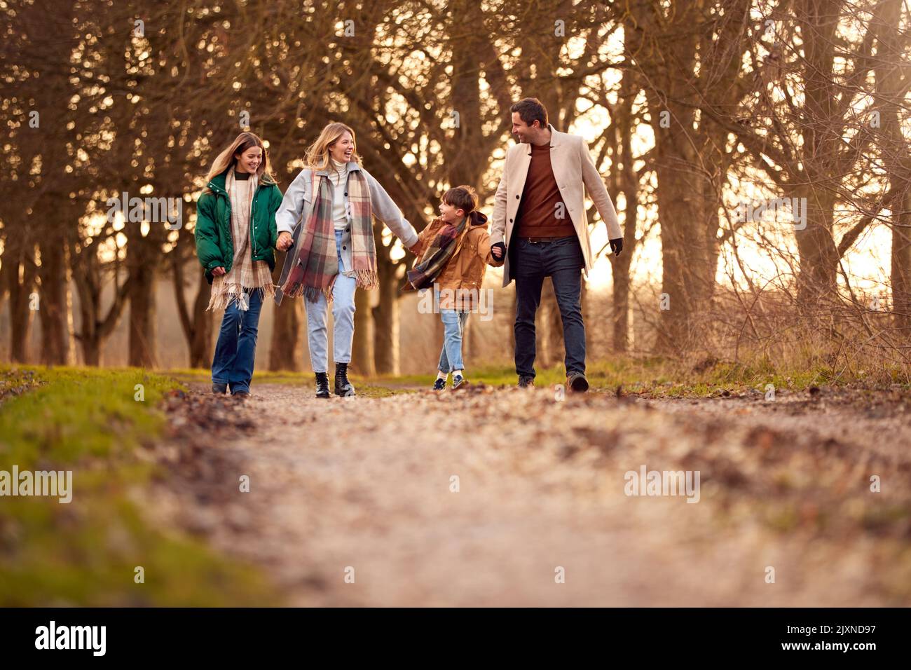 Family Holding Hands On Walk Through Autumn Countryside Together Stock Photo