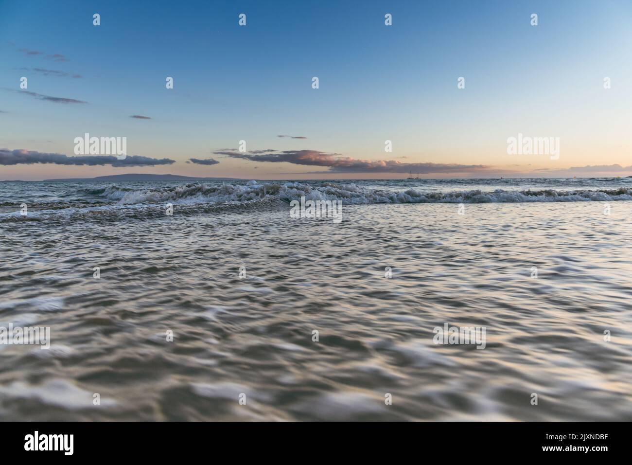 Maui Hawaii beach coastline of sand, sun, and blue water with crashing Stock Photo