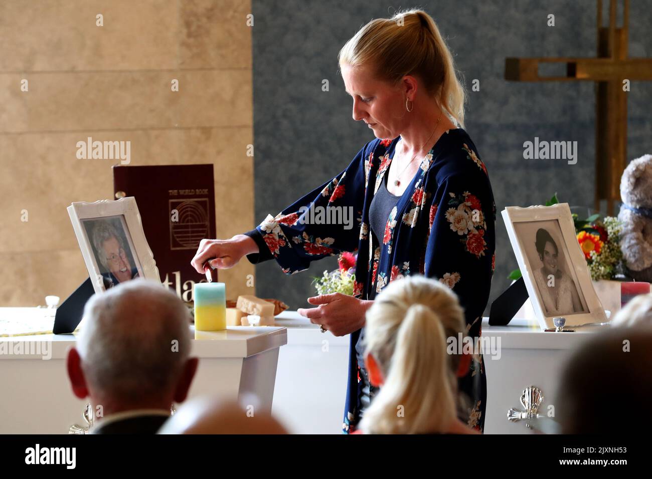 Taryn lights a candle on the coffin of her mother Beverley Quinn