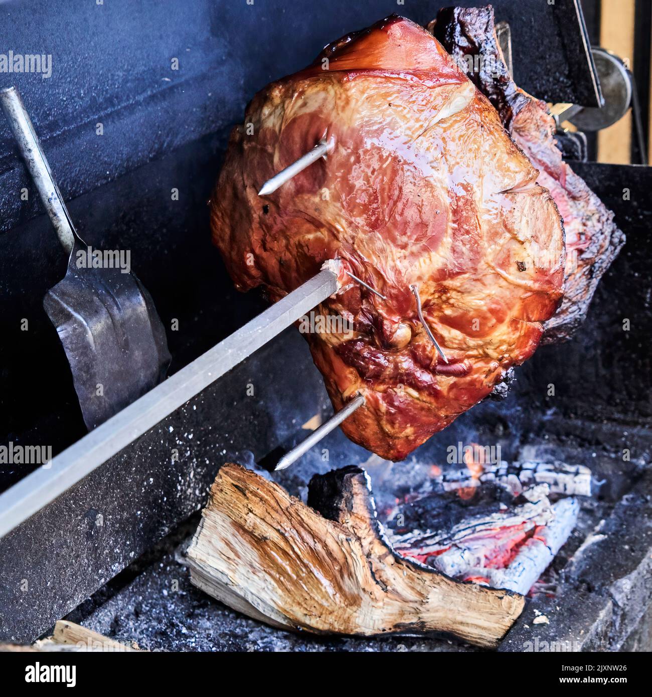 The famous Prague ham is grilled over an open fire on a rotisserie before being eaten by tourists Stock Photo