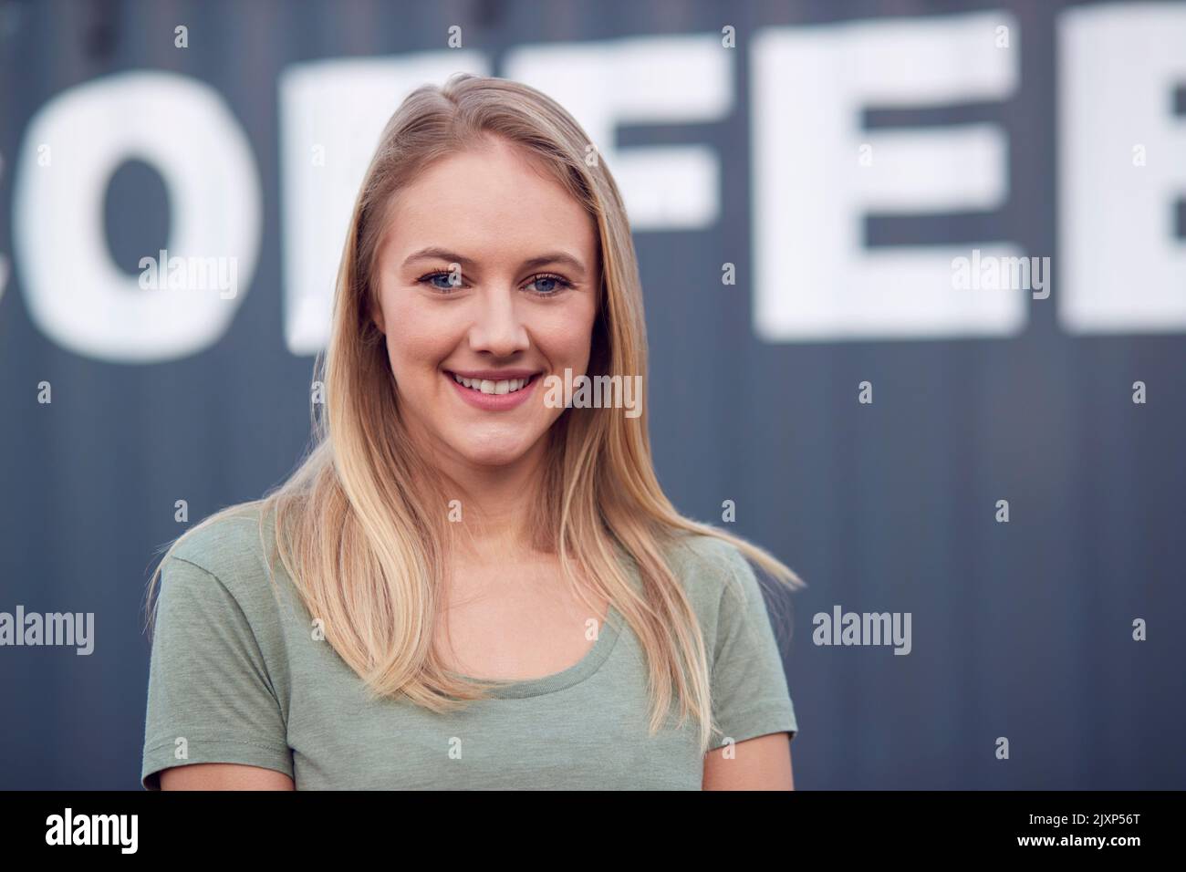 Portrait Of Female Intern At Freight Haulage Business Standing By Shipping Container Stock Photo