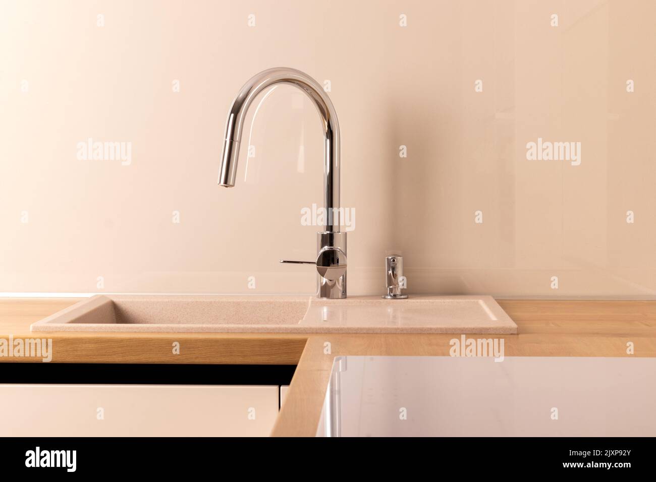 Chrome faucet and builtin dishwashing liquid soap dispenser in modern