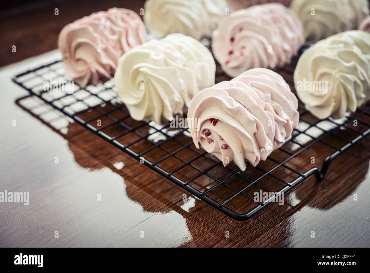 Cooling Rack with Homemade white and pink zephyr on wooden background Stock Photo