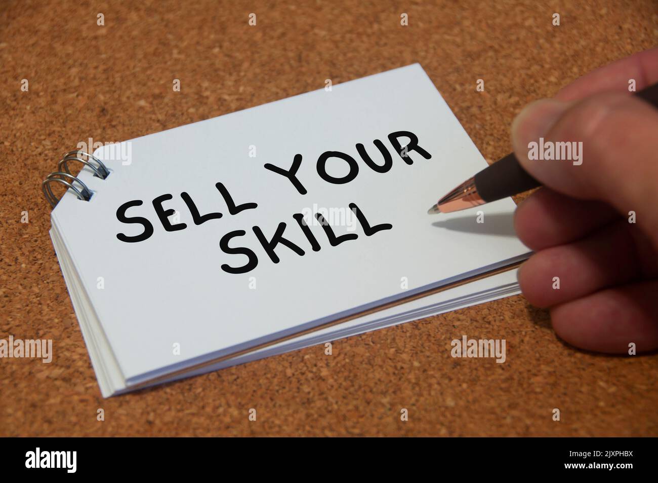 Hand writing sell your skill text on white notepad. Skill concept. Stock Photo