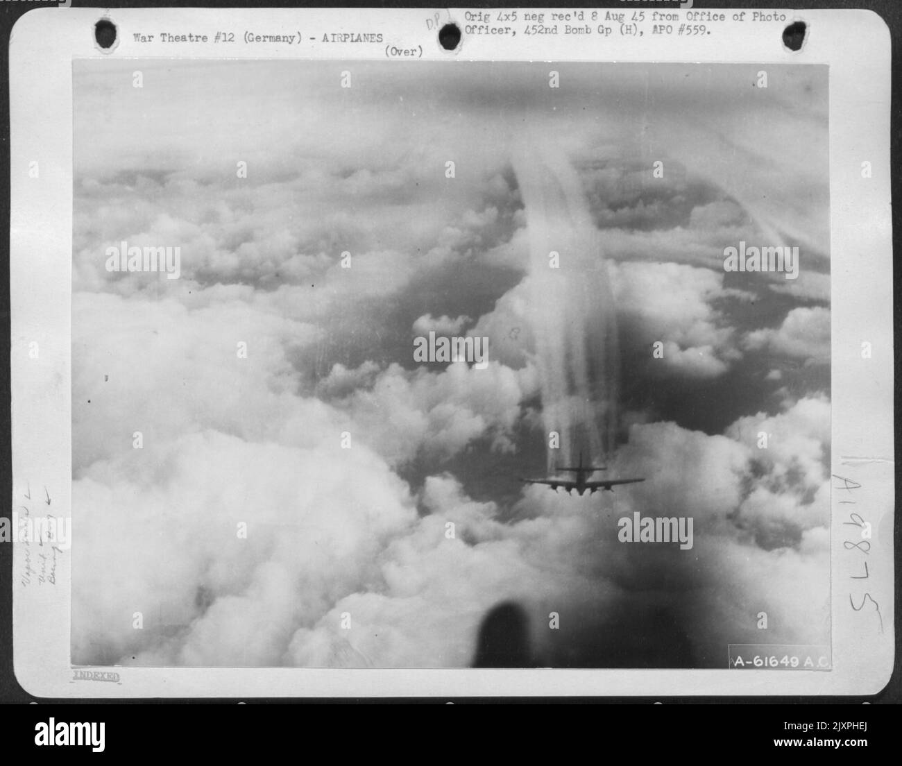 With Dense Cloud Formations Below It A Boeing B-17 Flying Fortress, Part Of A Formation Of The 452Nd Bomb Group Leaves Contrails Of Condensing Vapor To Mingle With The Clouds As The Formation Drones Toward Its Objective Of Frankfurt, Germany, 20 March 194 Stock Photo