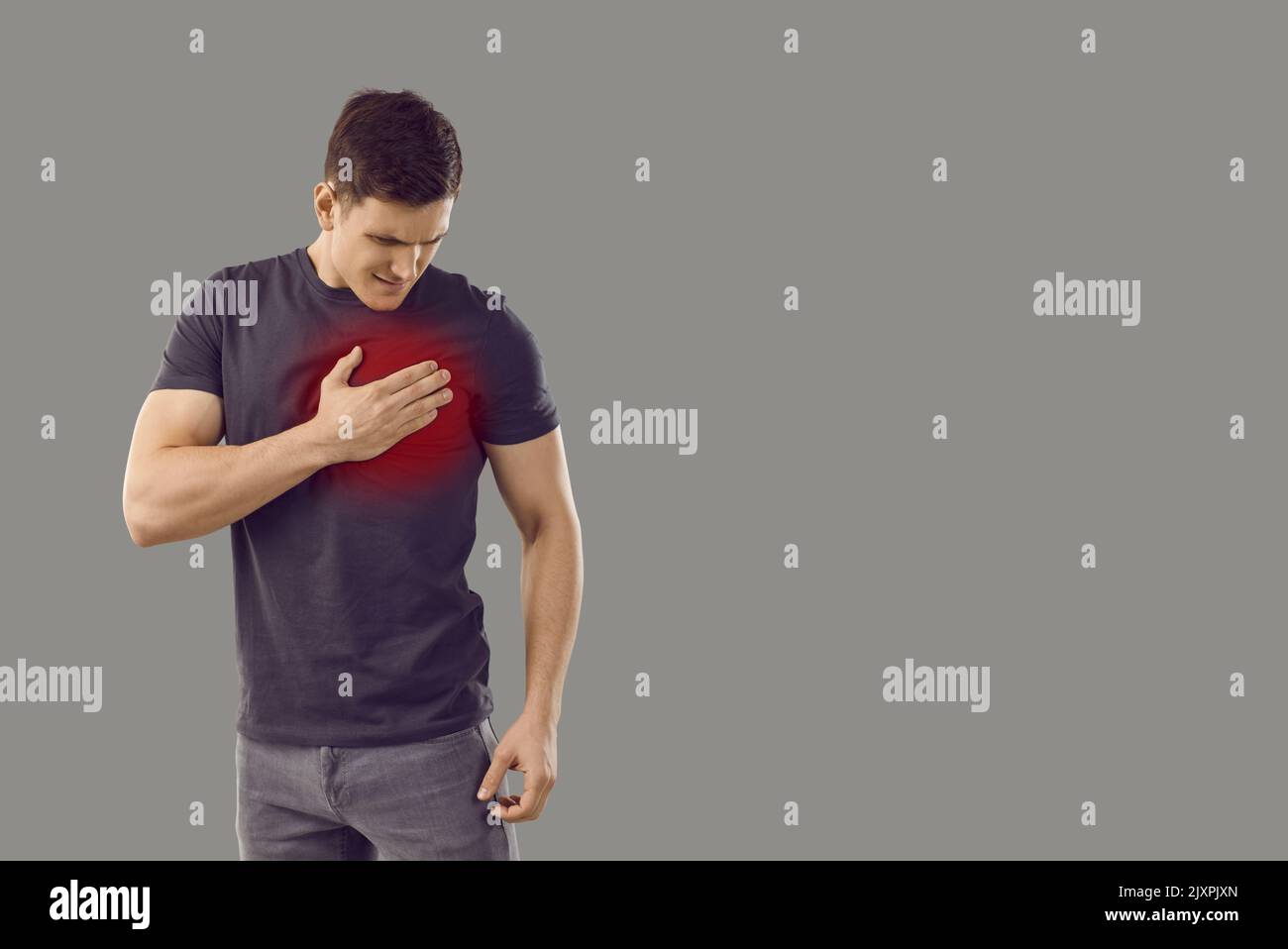 Man isolated on copy space background suffering from heart pain and touching his chest Stock Photo