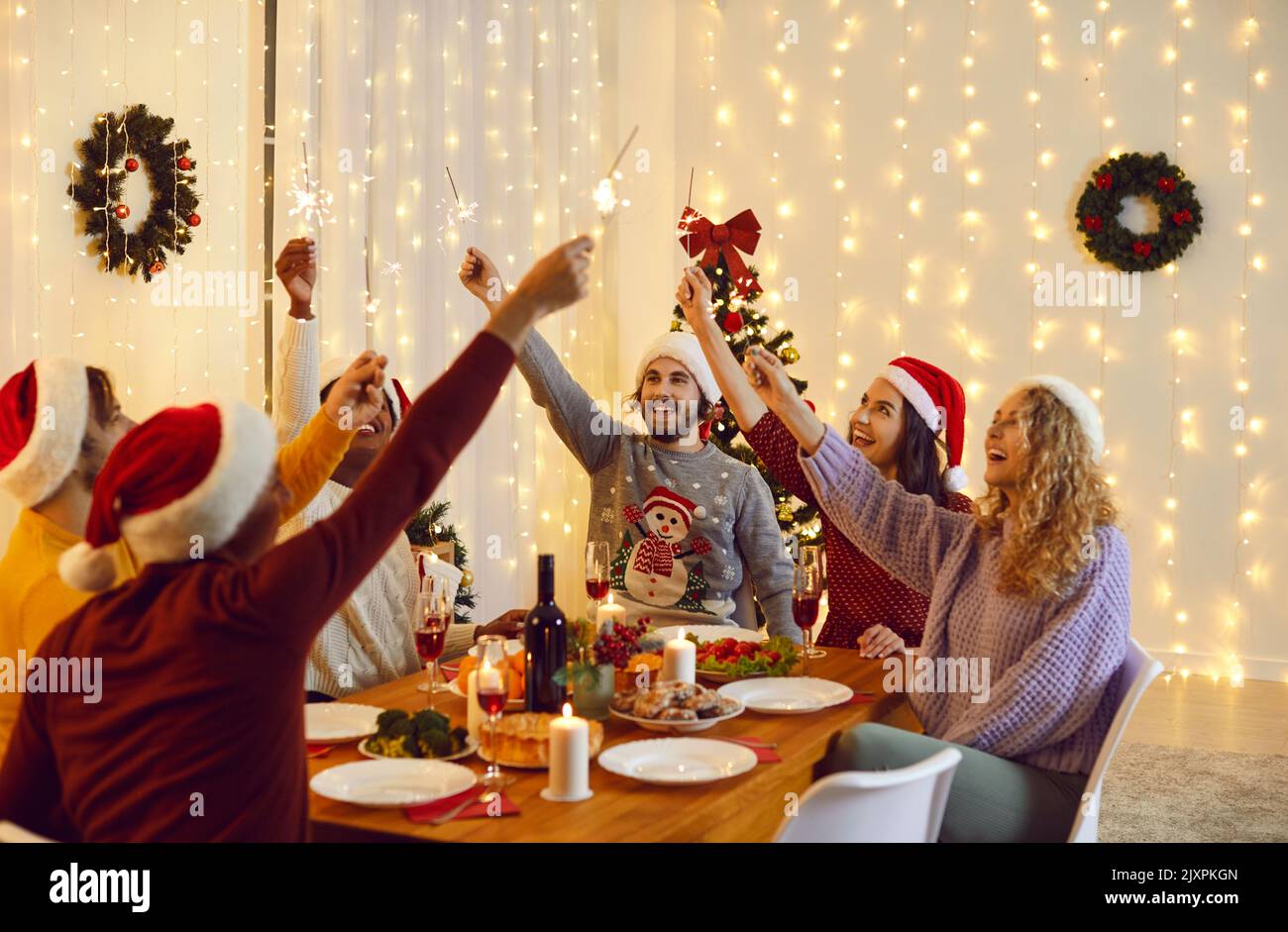 Cheerful millennial friends have fun lighting bengal lights during