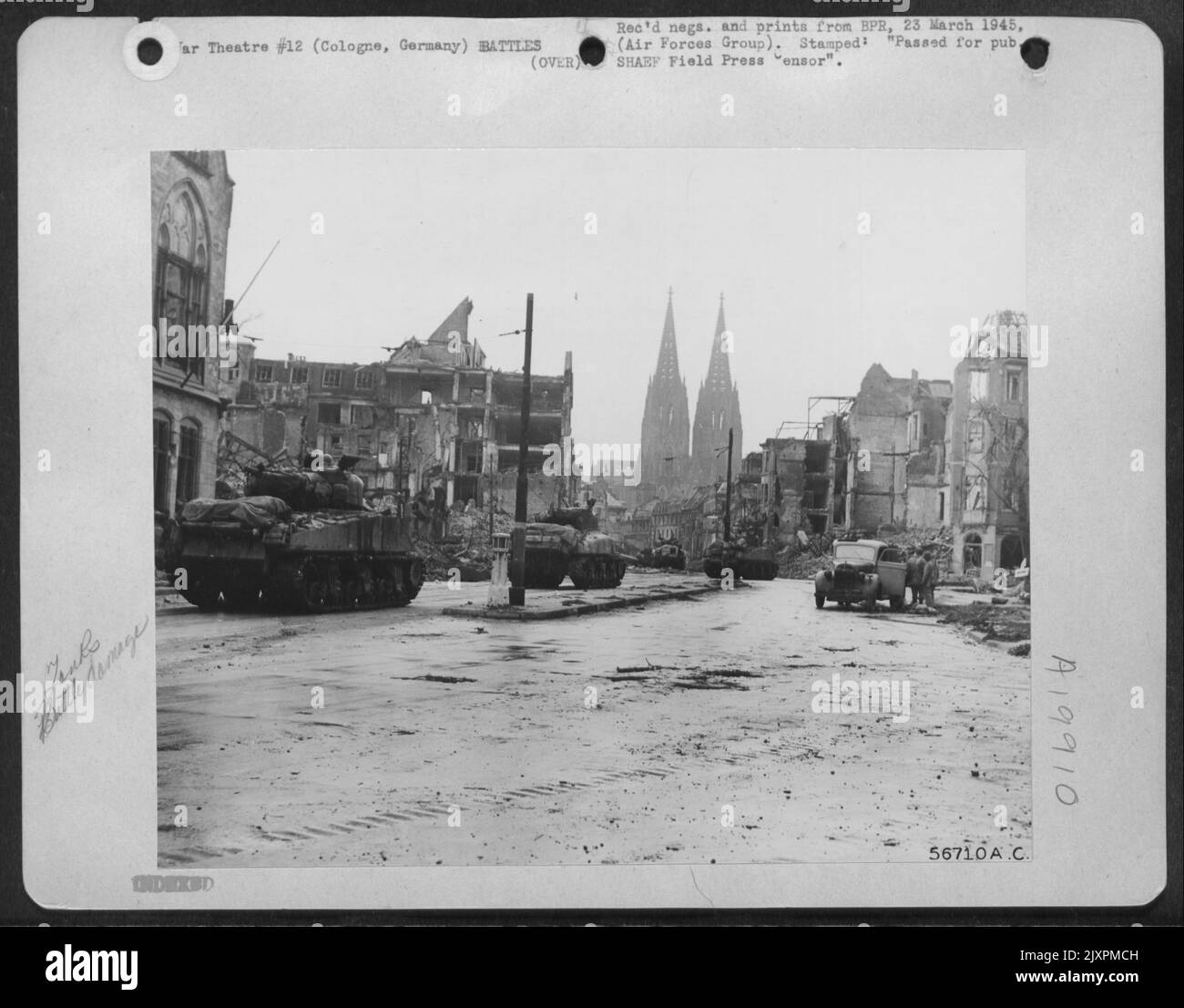 Tanks of the U.S. Third Armored Division roll through a debris lined ...