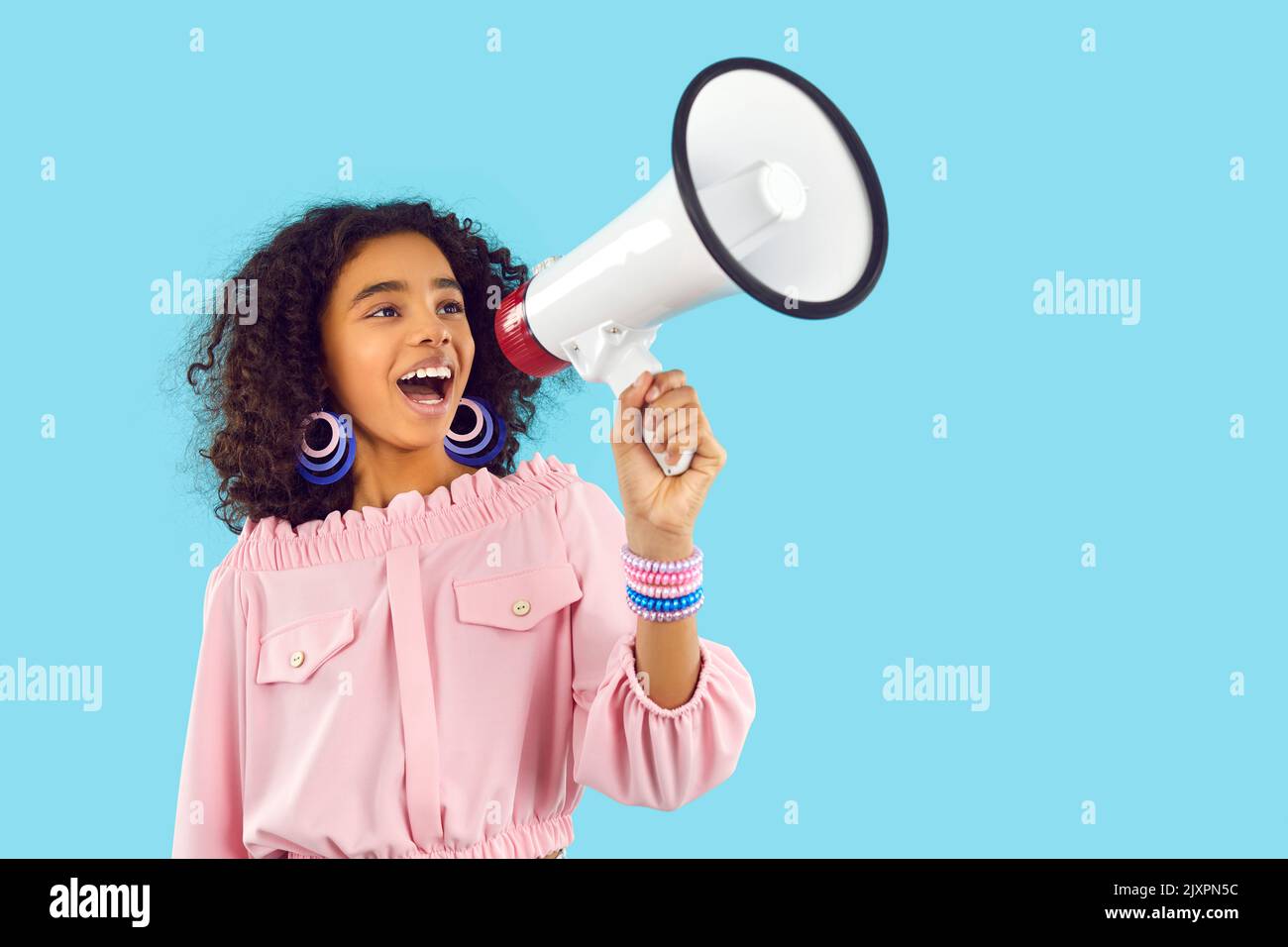 Happy child speaking through megaphone and making loud announcement about fashion sale Stock Photo