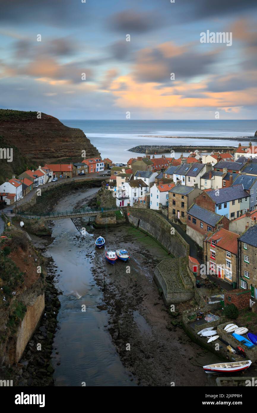 Clouds over the village of Staithes on the North Yorkshire Coast illuminated by the setting sun. Stock Photo