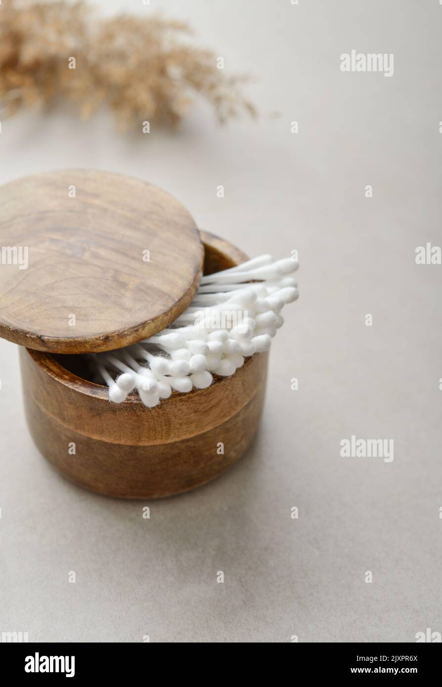 Сotton buds in wooden box on a light concrete background Stock Photo