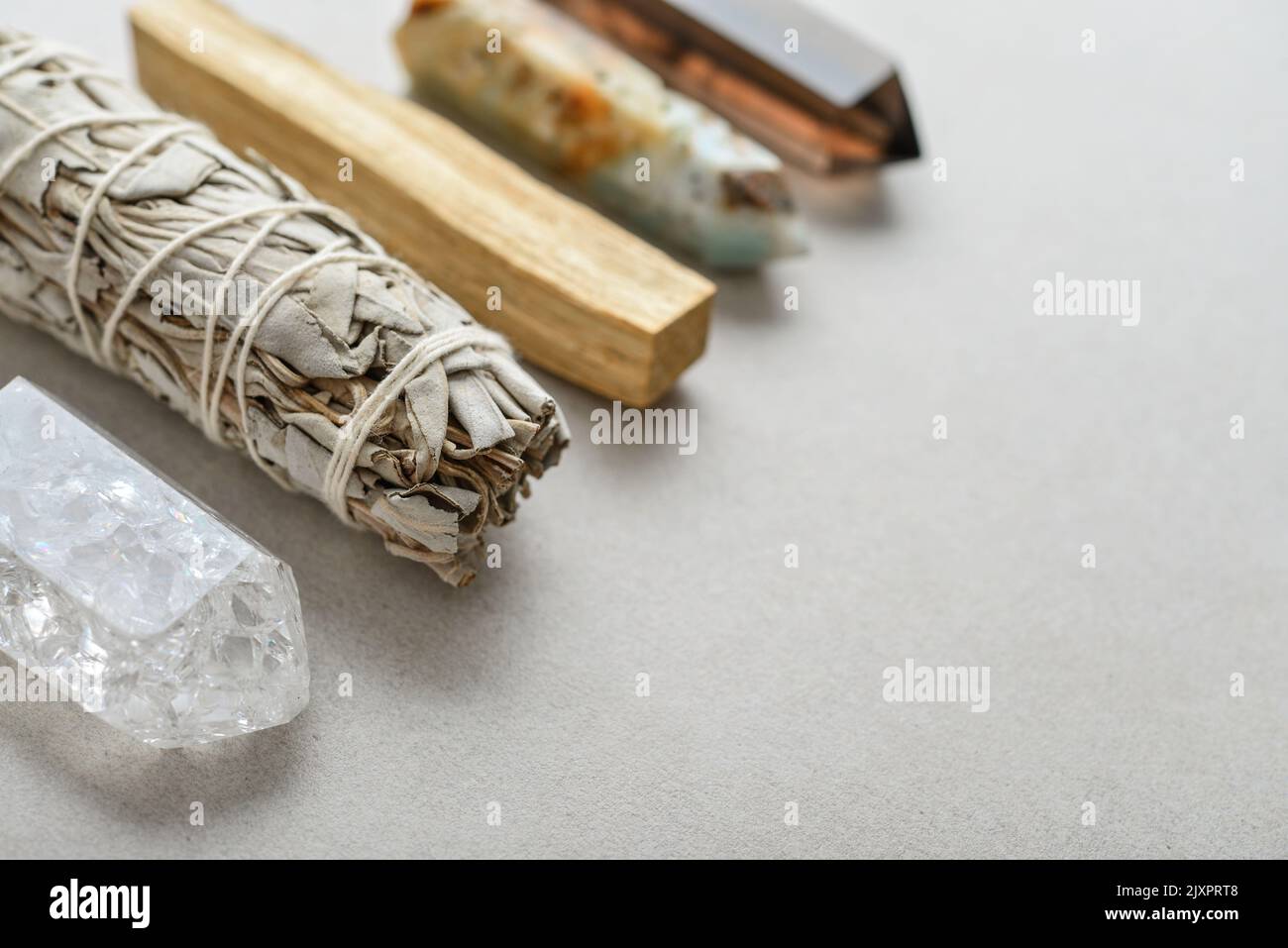 Set with white sage, palo santo and natural stone cristals. Natural elements for cleansing environment from negative energy, adding positive vibes. Stock Photo