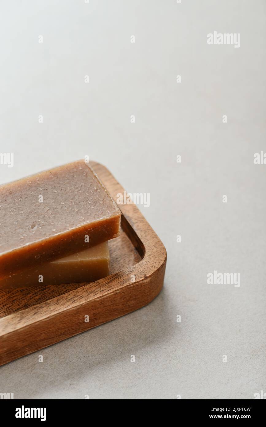 Natural handmade soap bars on wooden tray on a light concrete background Stock Photo