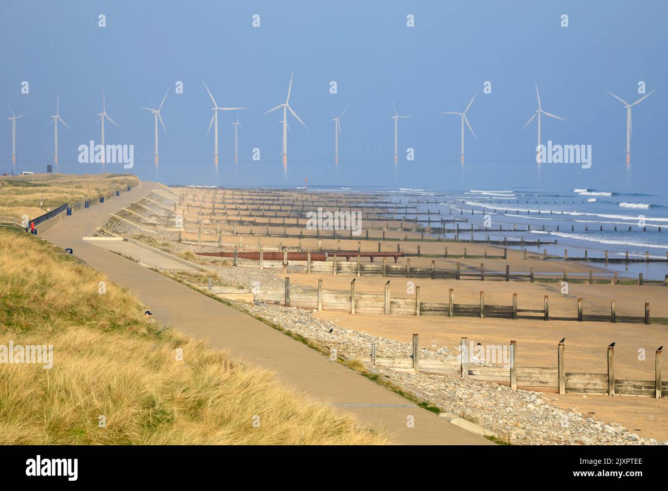 Groynes on the beach at Redcar with wind turbines in the distance. Stock Photo