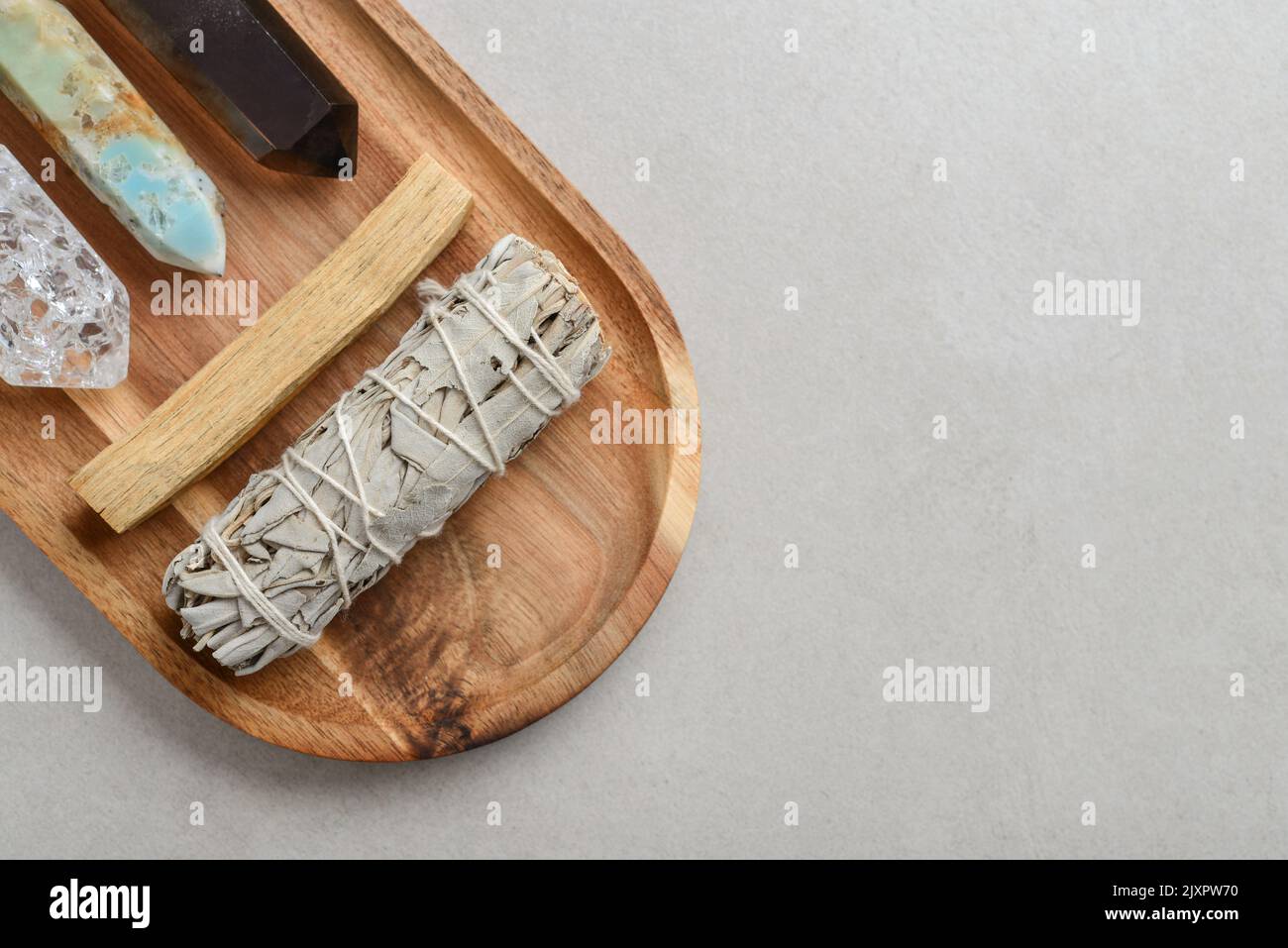 Set with white sage, palo santo and natural stone cristals. Natural elements for cleansing environment from negative energy, adding positive vibes. Stock Photo