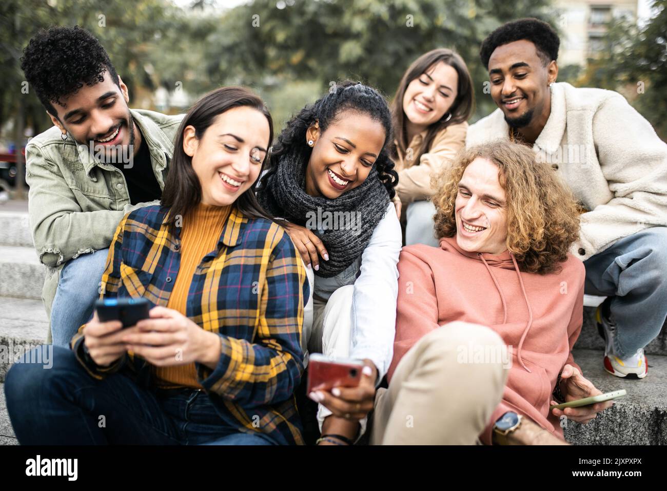 Young group of multiracial student friends using mobile phone in the city Stock Photo