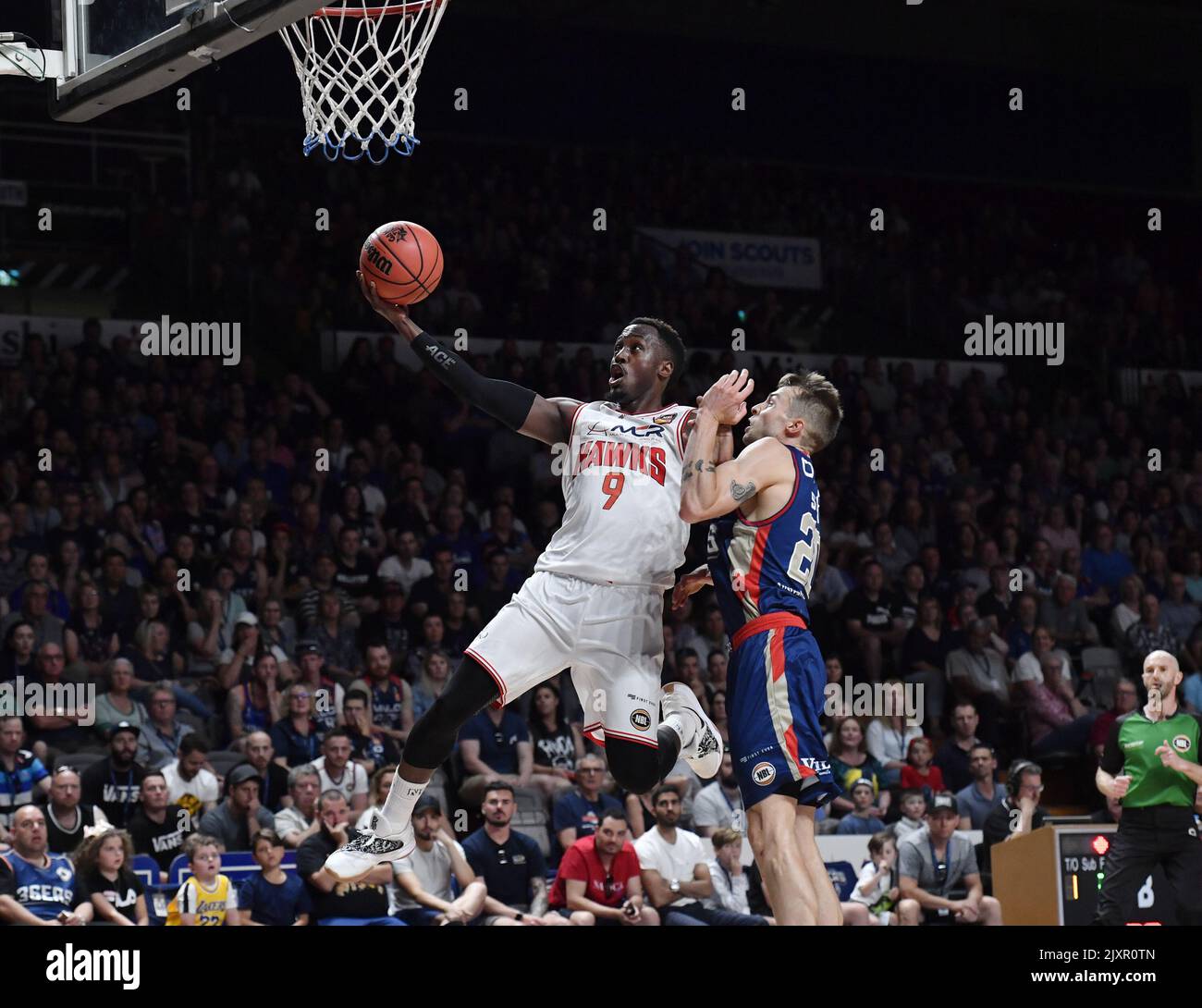Cedric Jackson of Illawarra Hawks scores while Nathan Sobey of