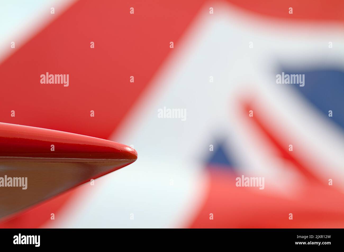 Wing Tip Of A Royal Air Force Red Arrow Hawk T1 Acrobatic Display Jet Against The Red White And Blue Union Jack Of The Tail, Bournemouth UK Stock Photo