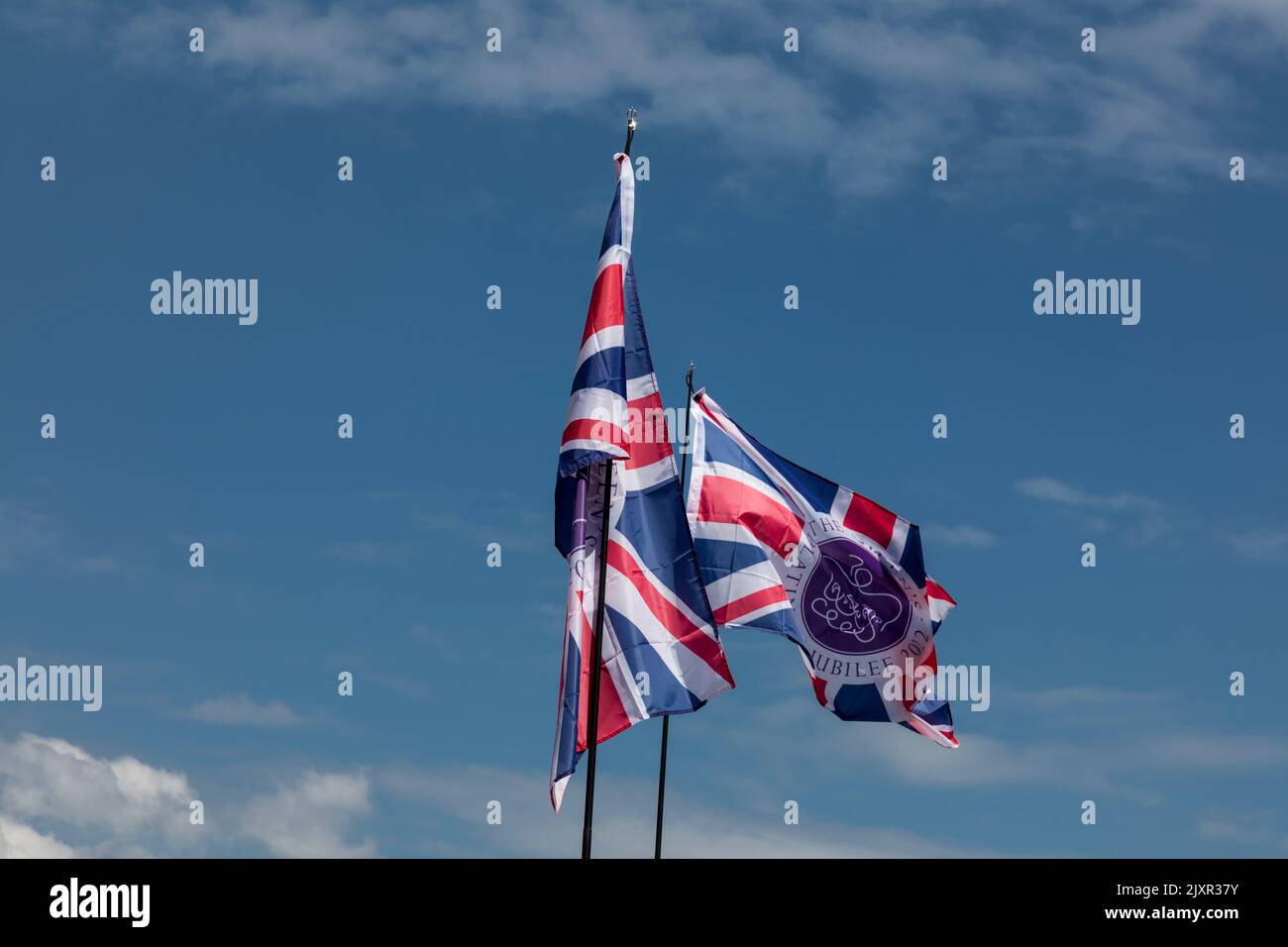 Special Platinum Jubilee Union flags fly against a blue sky. Stock Photo
