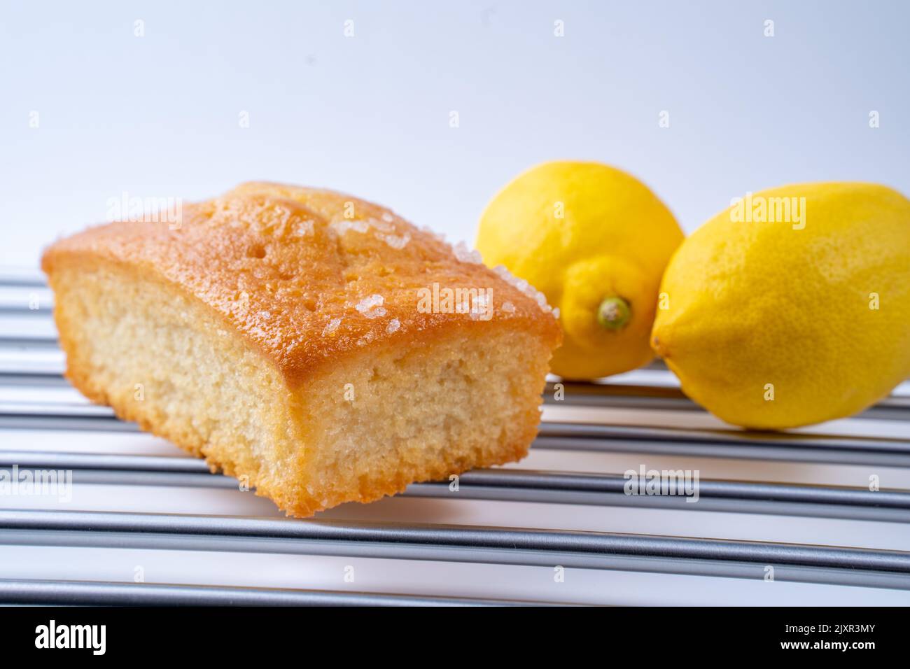 Home made Lemon Drizzle loaf tin cake on a stainless steel rack with