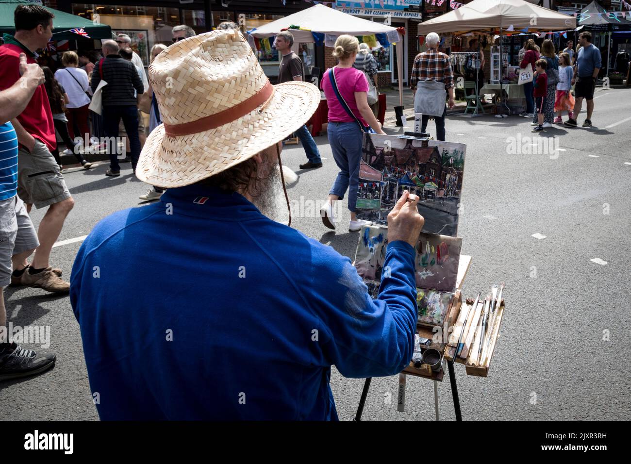 An artist paints stalls and crowds during the Haslemere Charter Fair. Stock Photo