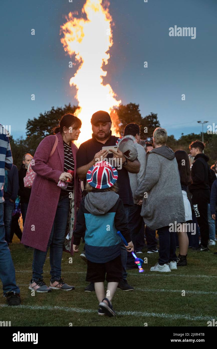 The beacon burns brightly whilst crowds enjoy the atmosphere, as part of the Haslemere celebrations for the Queen's Platinum Jubilee. Stock Photo