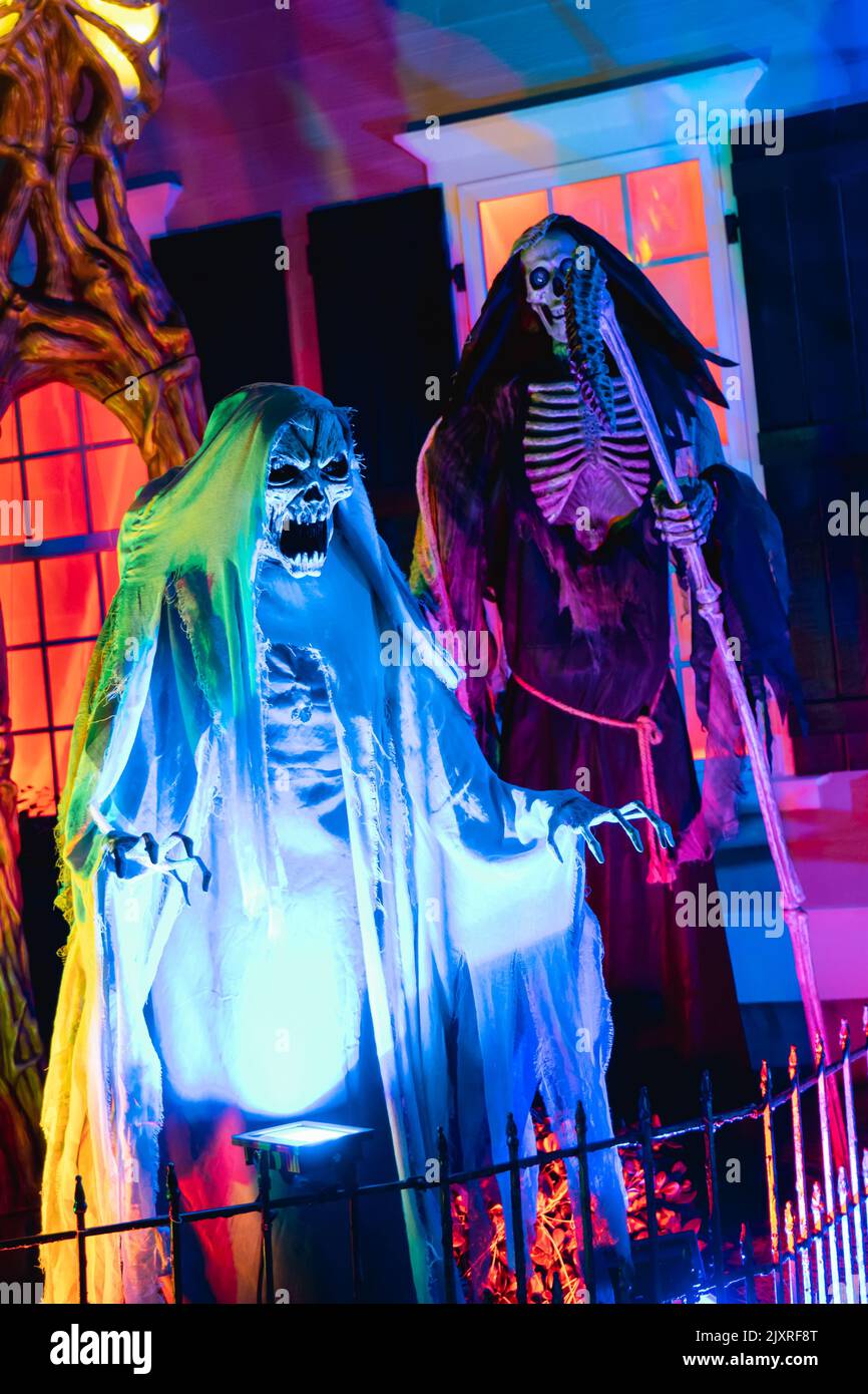 A scary clown decorations in a haunted house for Halloween swinging on a swing Stock Photo